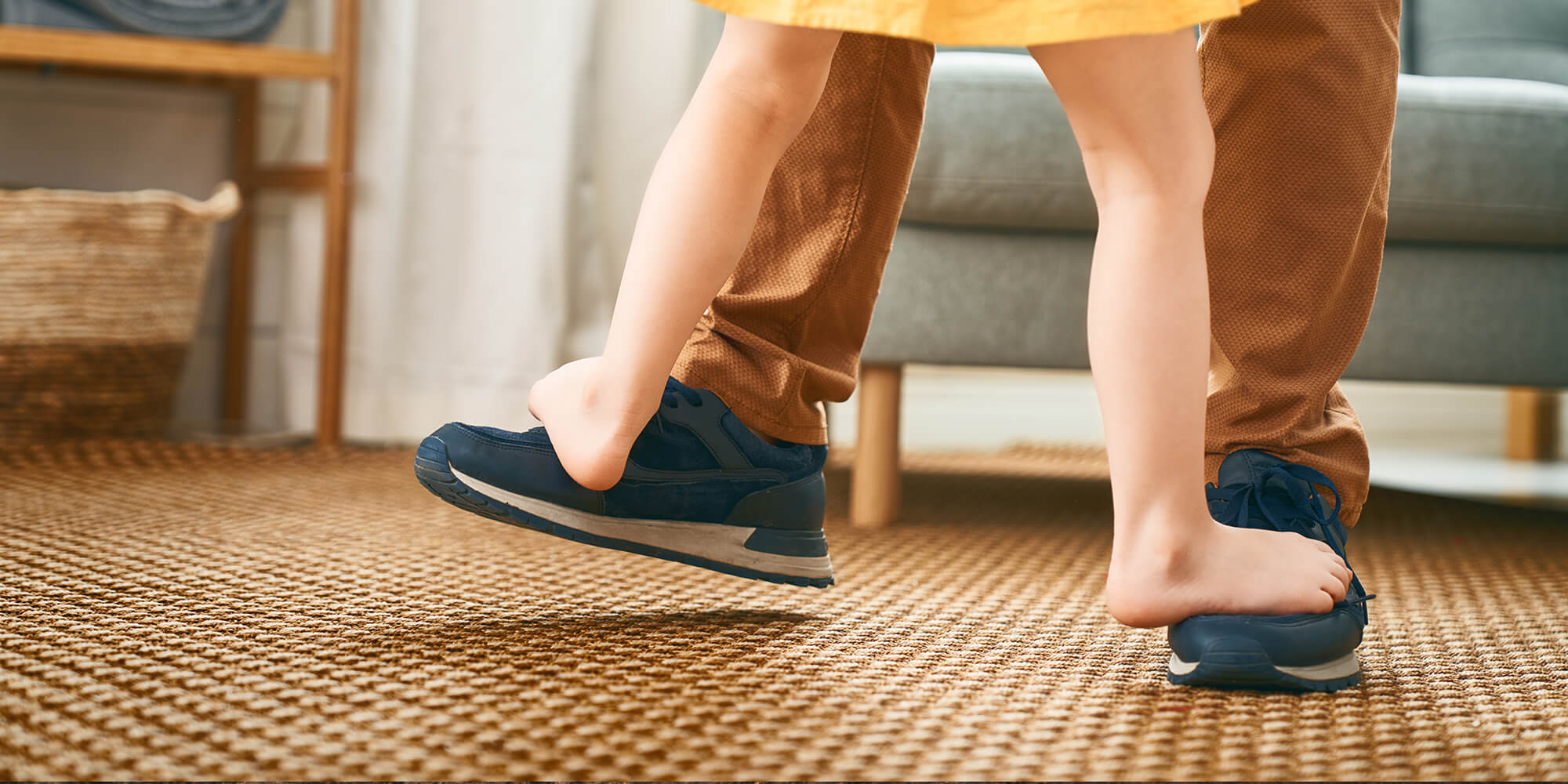 Clinique podiatrique Stéphanie Brodeur | Gros plan sur une enfant nu pied sur les pieds de son père et dansant